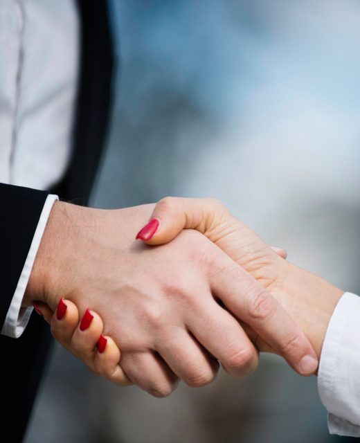 close-up-business-colleagues-shaking-hands-city